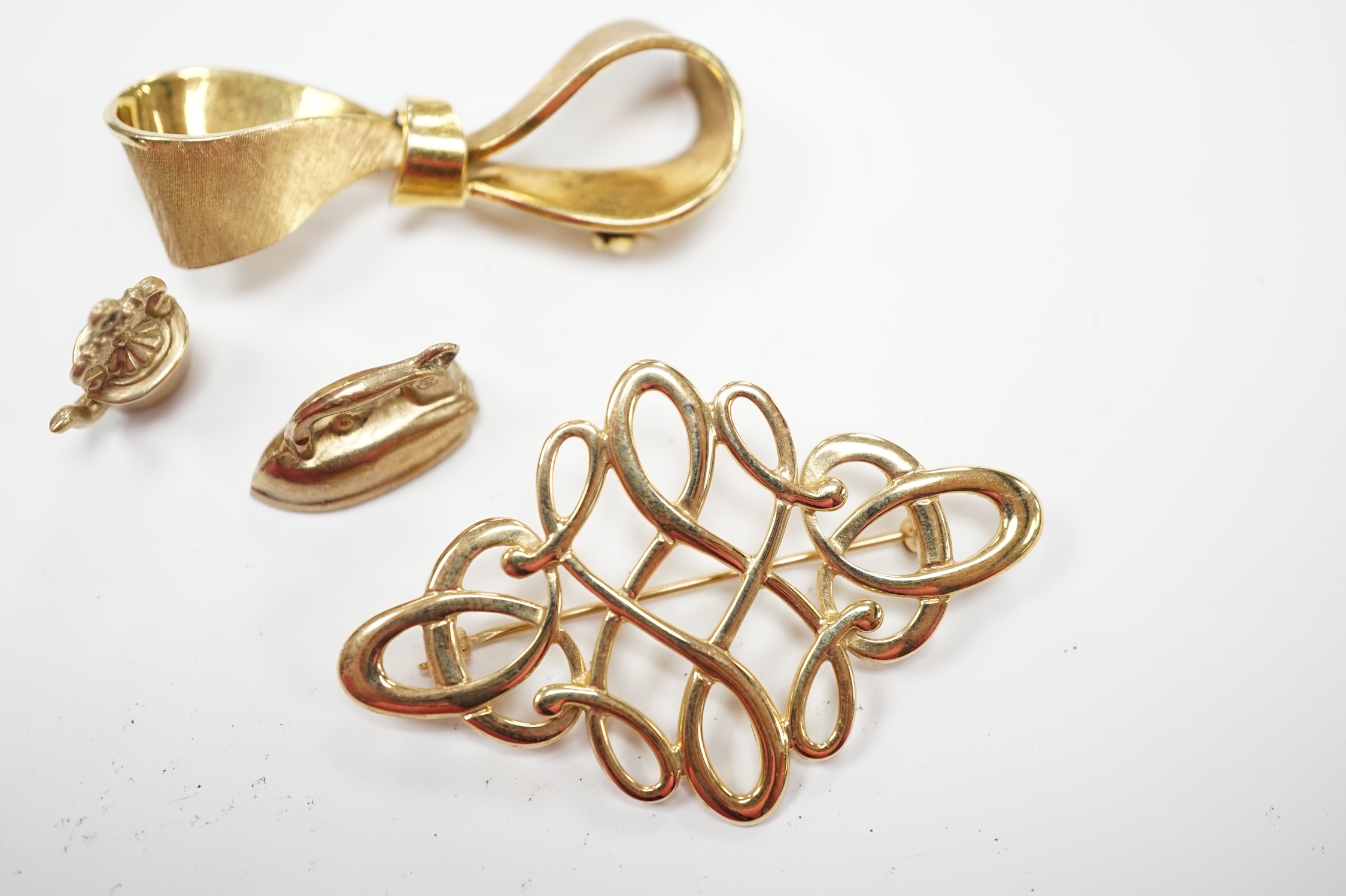 Two modern 9ct gold brooches, including ribbon bow, 45mm and two 9ct gold charms, 12.5 grams. Fair condition.